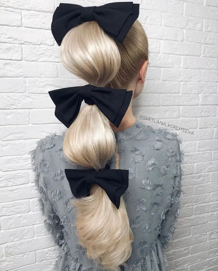 Playful bubble ponytail with vibrant bow.