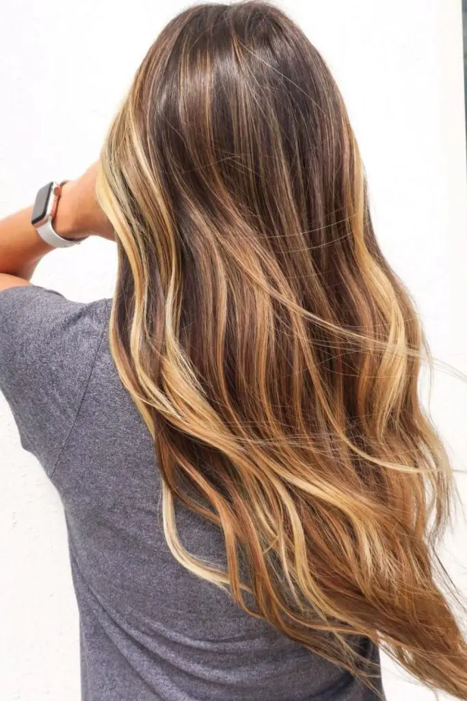 Soft caramel highlights with warm blonde tones.
