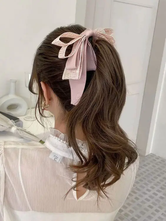 Modern sleek ponytail with bold bow.