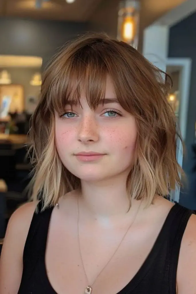 Sharp blunt bangs with flowing shag layers.