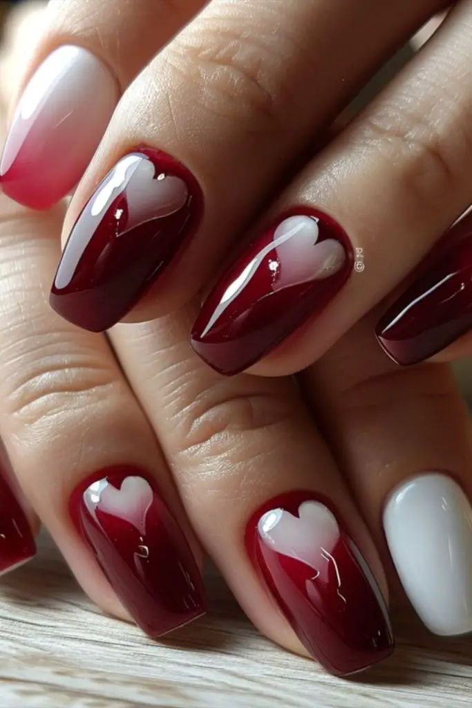Deep red matte nails with hearts.
