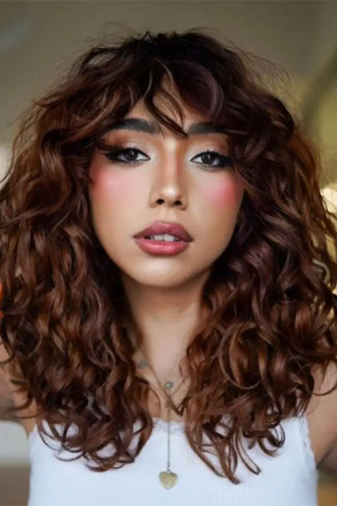 Curly bangs adding volume and playful energy.