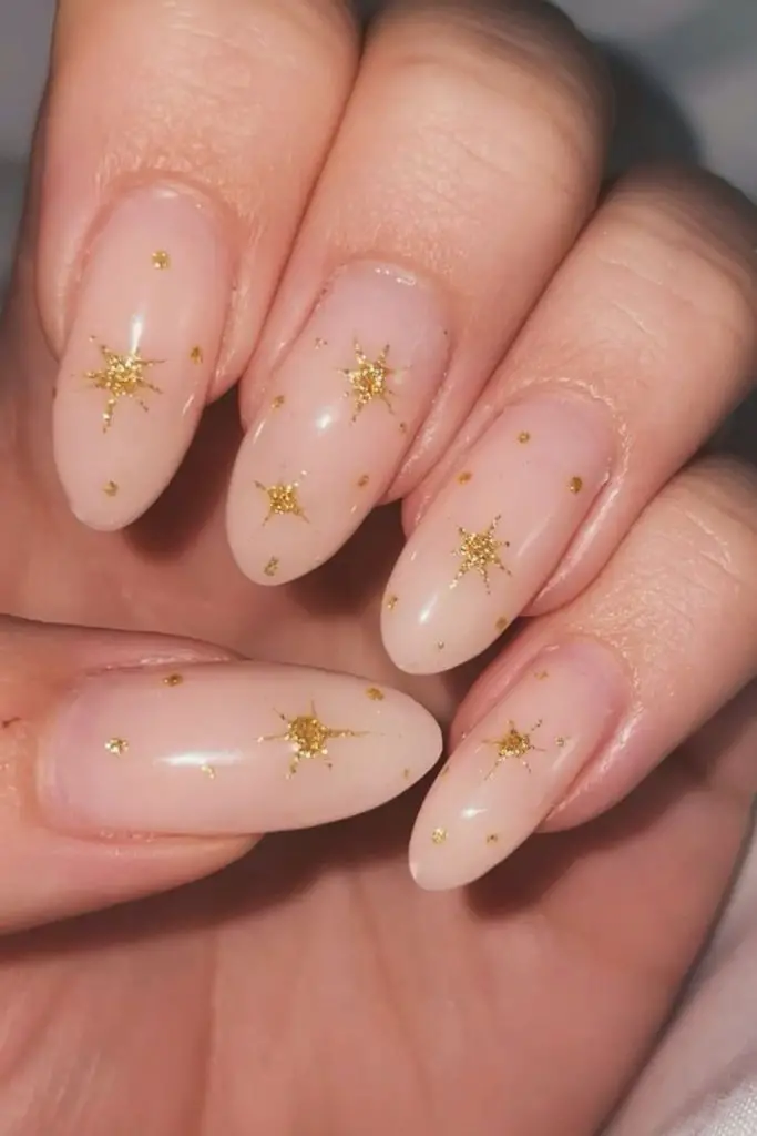 Golden nails with minimalist art charm.