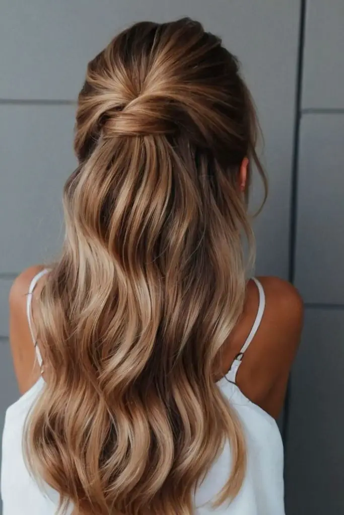 Half updo with soft curls and layers.