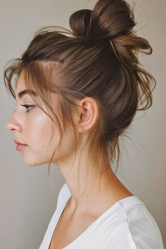 "Messy bun adding height and fullness."