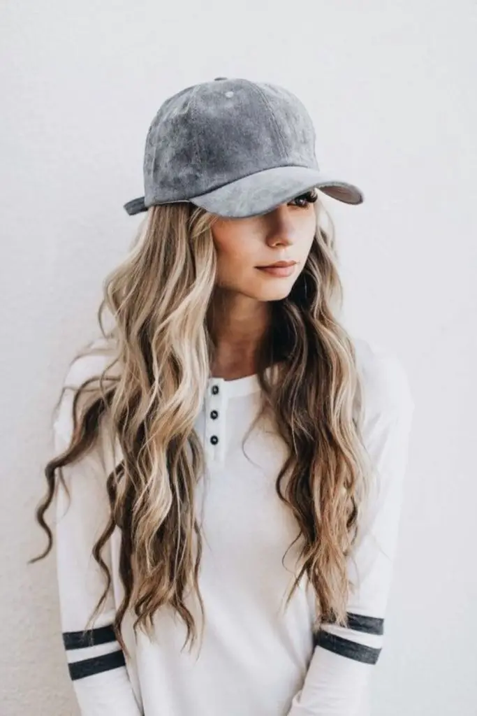 "Curly hair topped with a cozy hat."