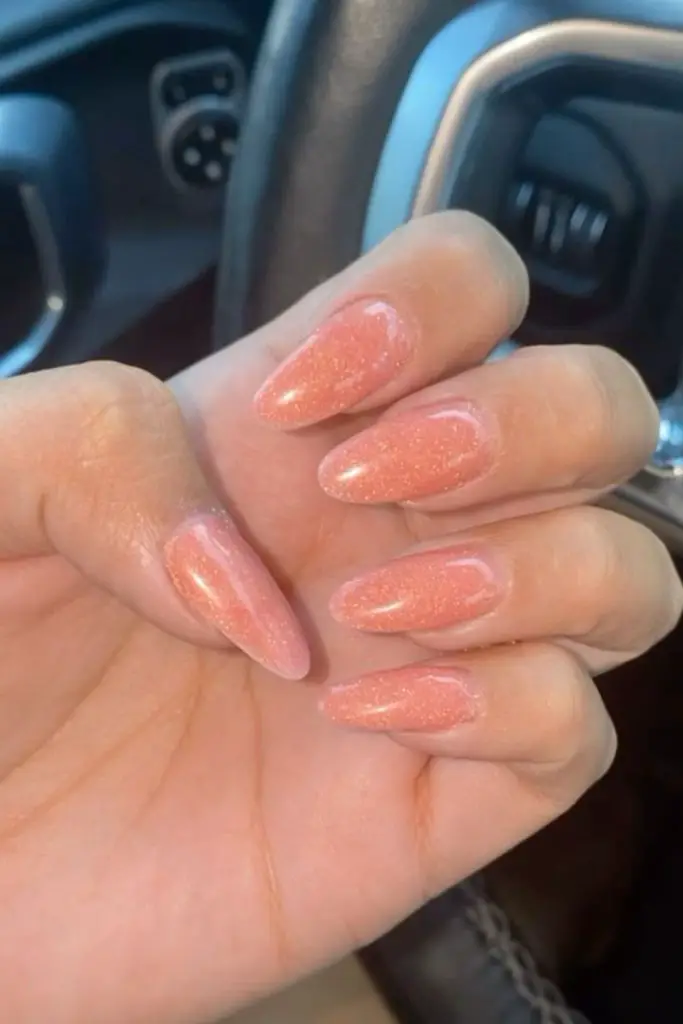 Sweet peach nails with glittery shine.