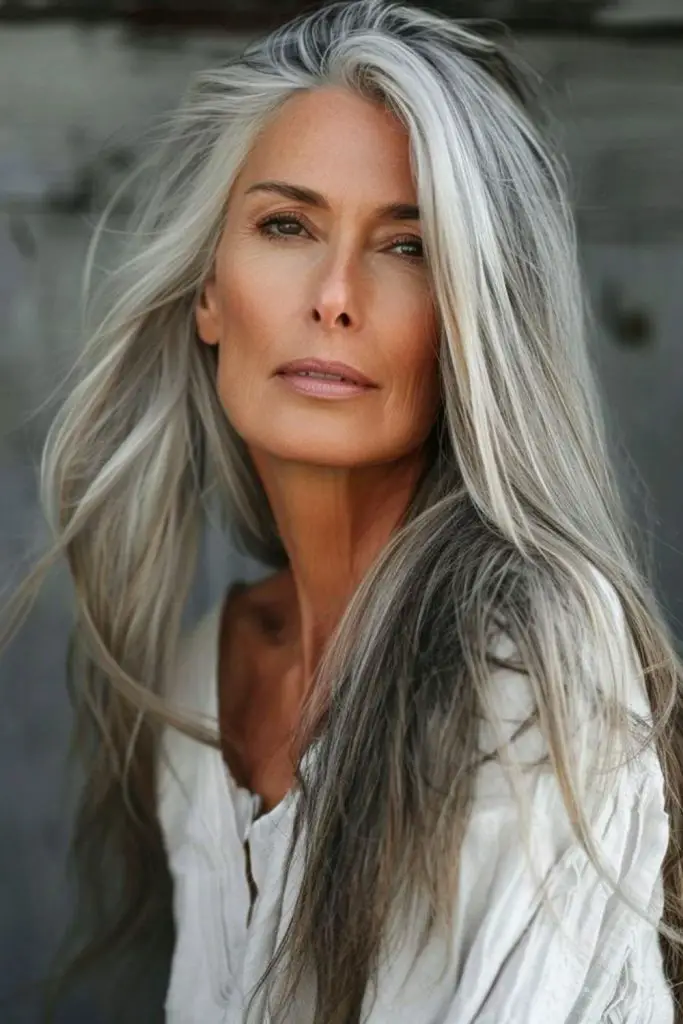Long layered gray hair with side-swept elegance.