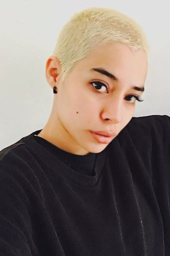 Pale buzzed hair with subtle curves.