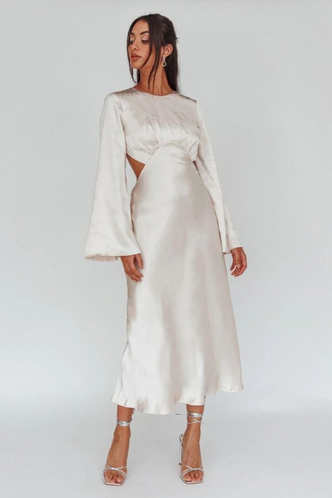 "Cream bell-sleeve dress with flowing skirt."