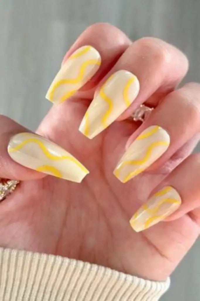 Geometric pastel yellow striped nails.