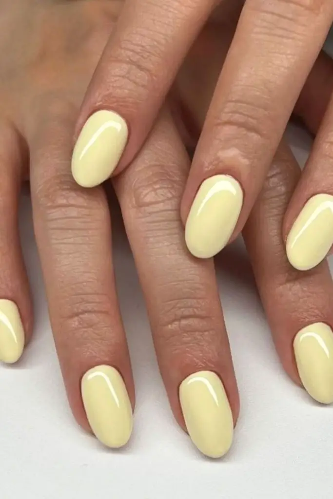 Melted pastel yellow rounded nail tips.