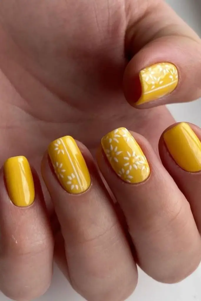 Yellow nails sprinkled with faint freckles.
