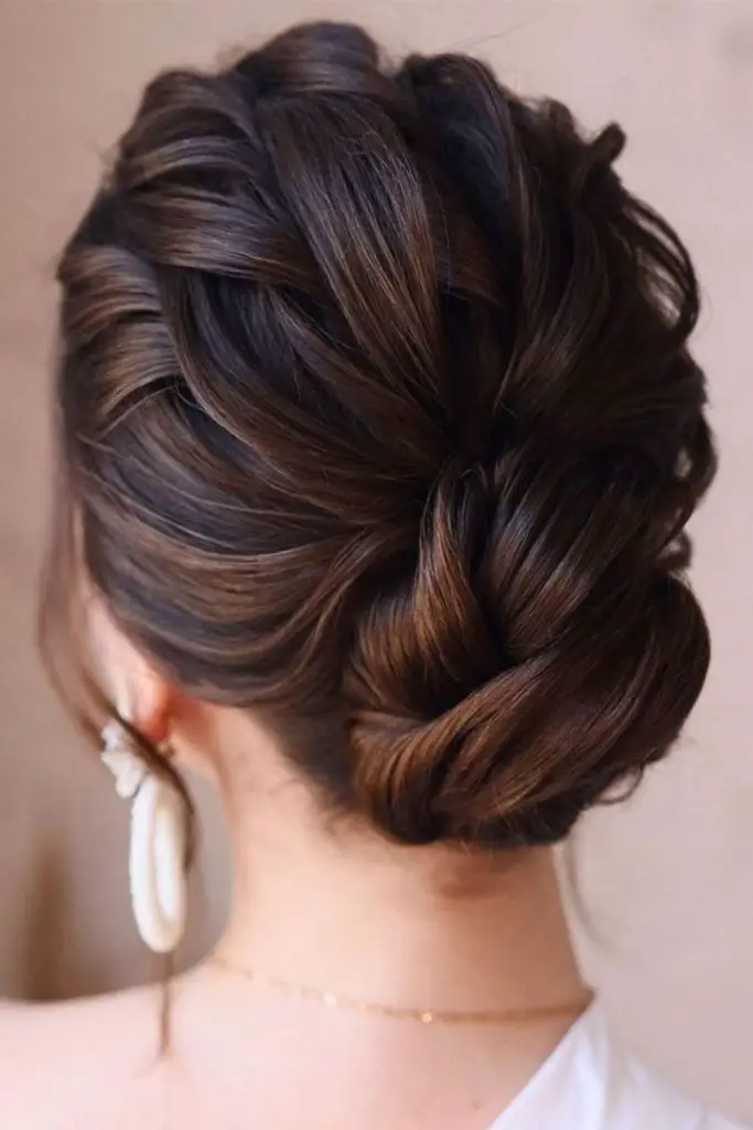 "Effortless tousled updo with loose tendrils."