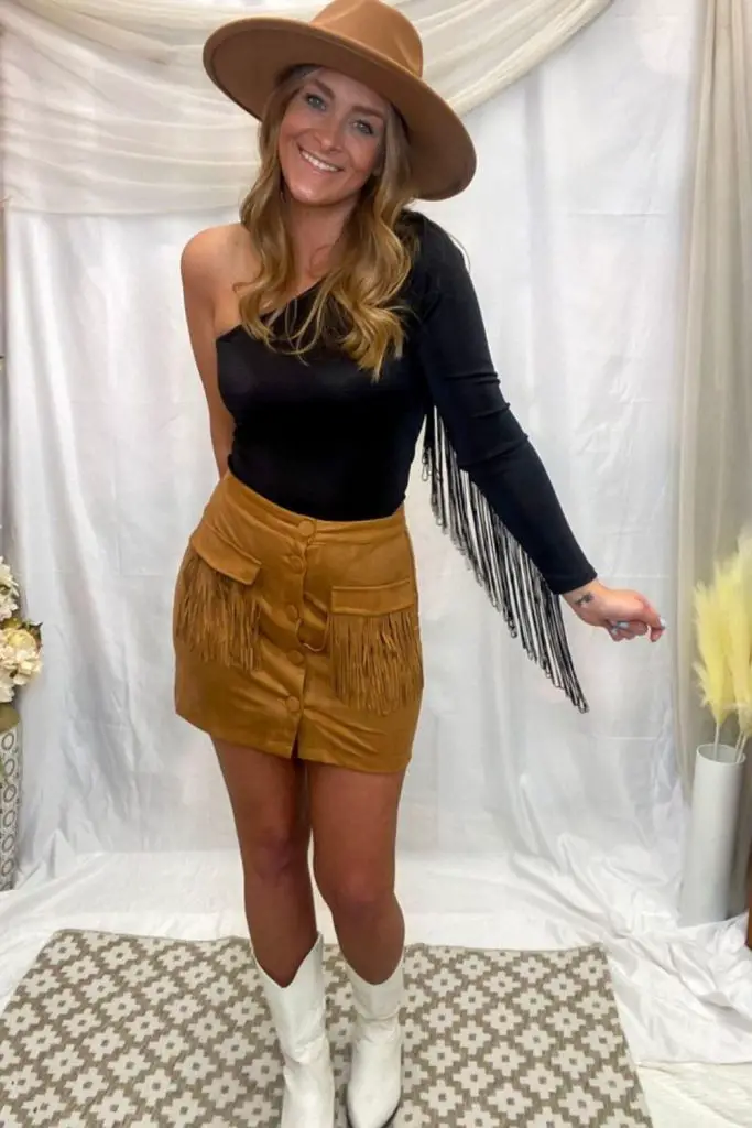 One-shoulder black top and fringe skirt.