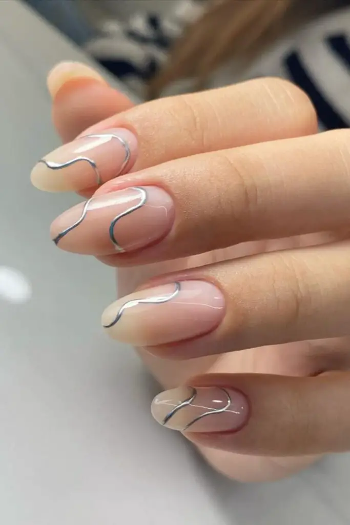 Beige nails with silver barbed design