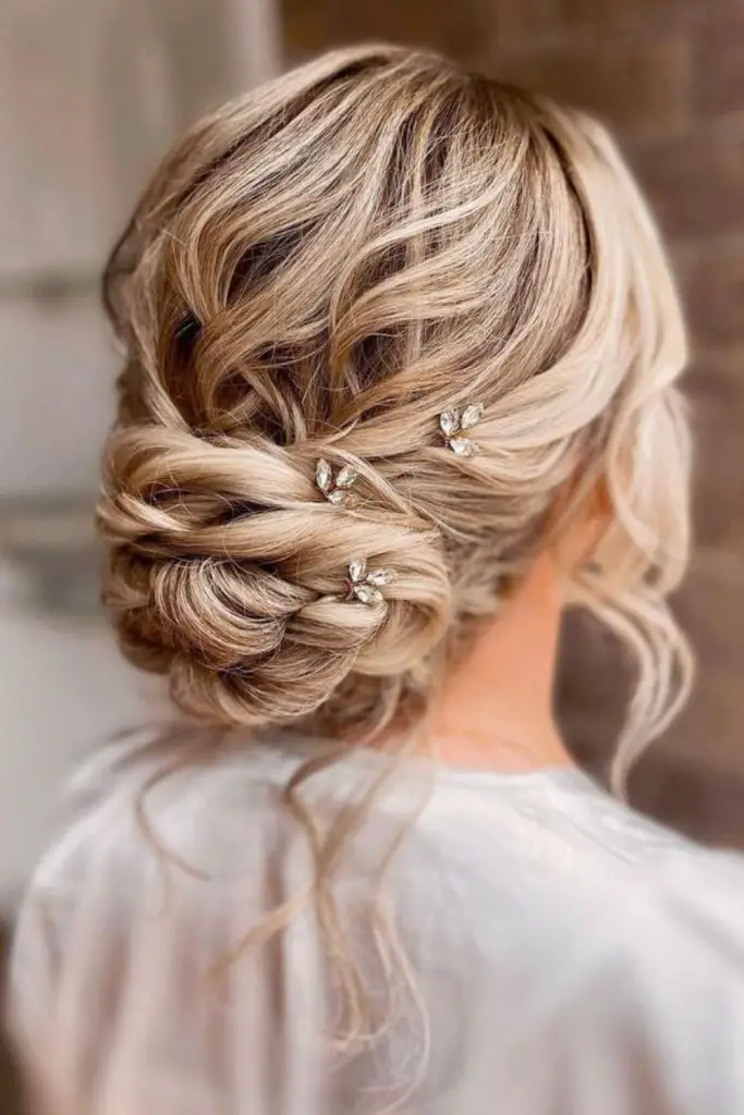 Curly updo adorned with scattered pearls.
