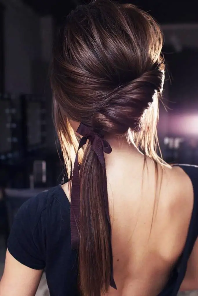 Side ponytail wrapped in frayed ribbons.