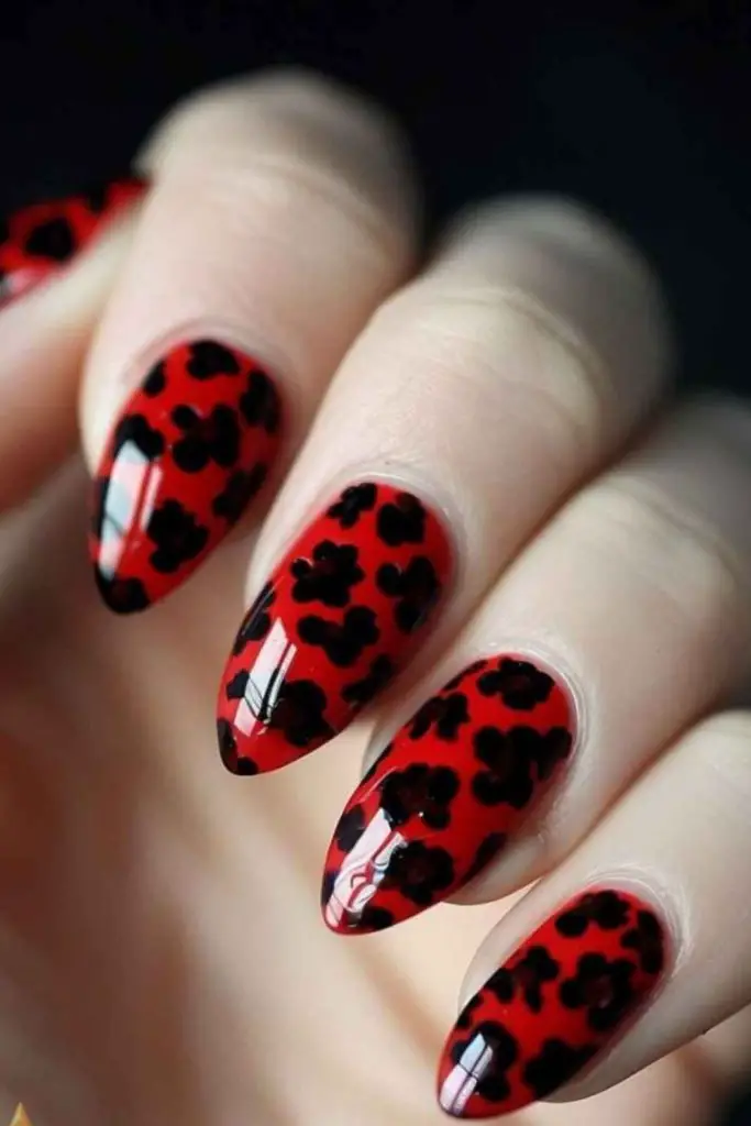 Red nails with cow print accent