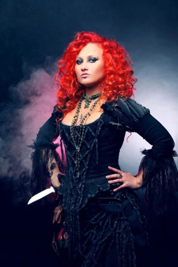 Dark fairy crowned with ruby strands.