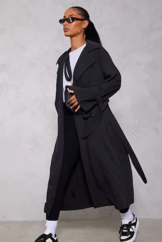 Black trench coat over cropped sweater.