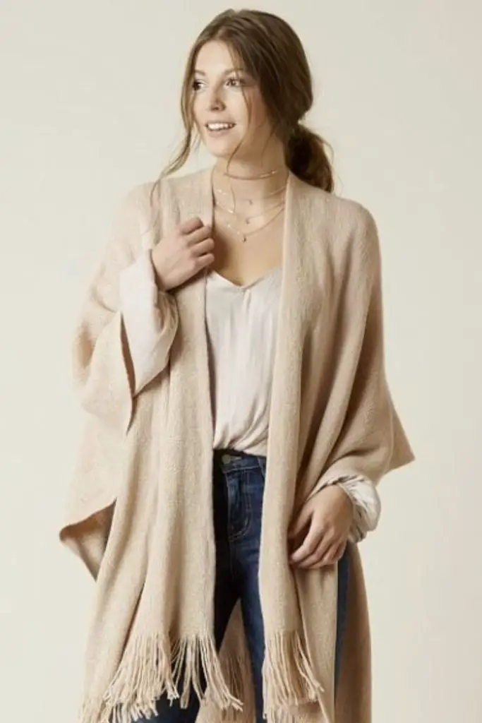 Wool poncho with acid-wash jeans.