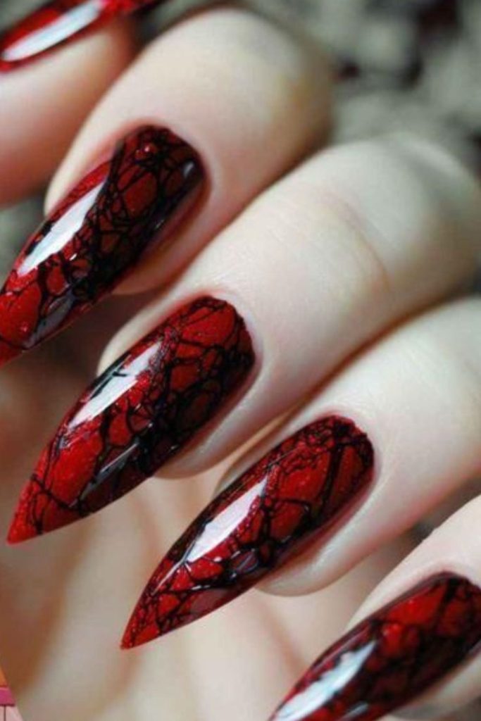 Crimson spider web spooky nail pattern.