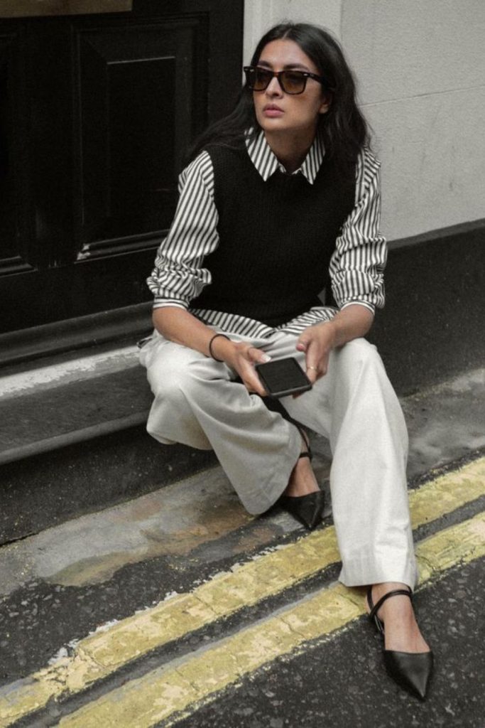 Striped shirt layered with sleek vest.