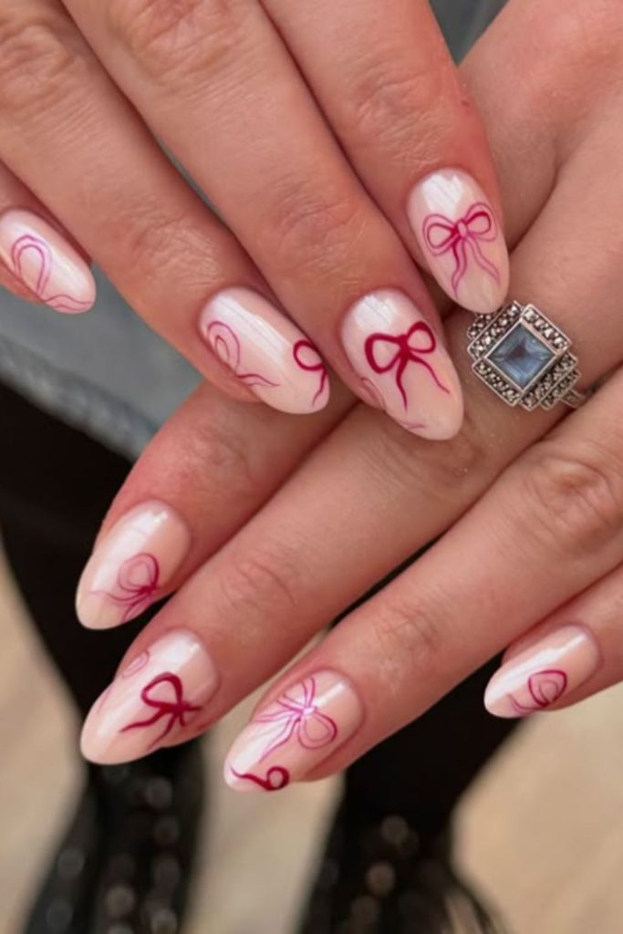 Pink nails with ribbon bow art.
