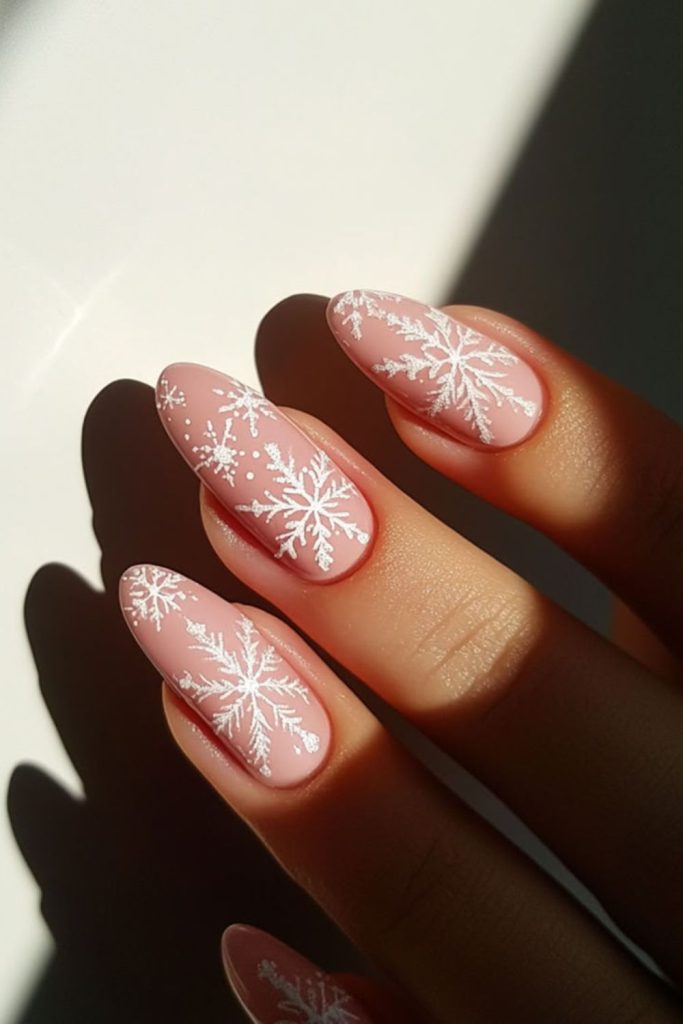 Snowflake art on soft pink polish.