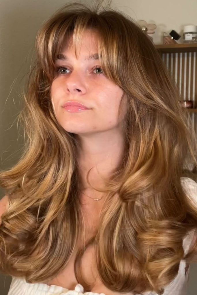 Sun-kissed honey curtain bangs flowing