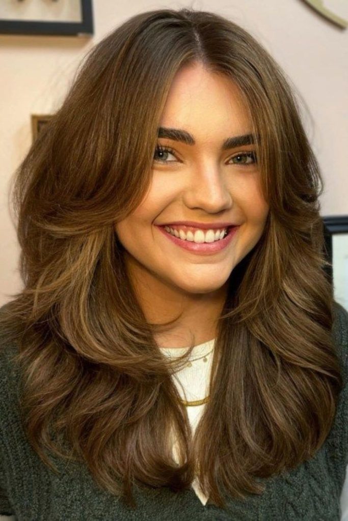 Curtain bangs sweep softly across cheeks