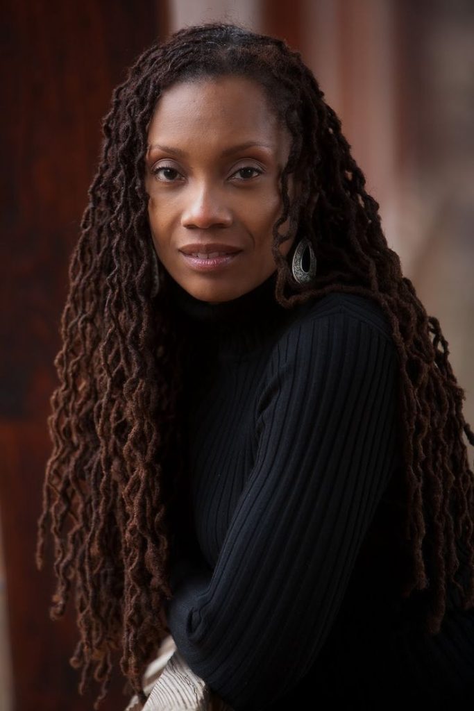 Deep auburn locs glowing under light