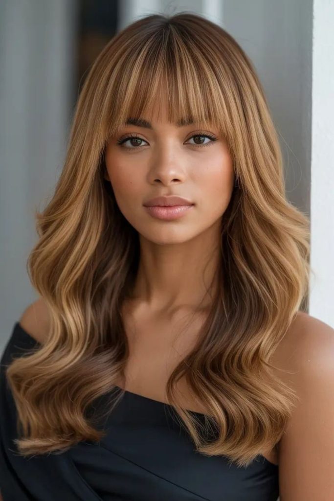 Flip bangs with honey shimmer streaks.