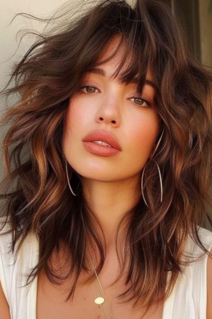 Soft caramel flowing shaggy layered hair.