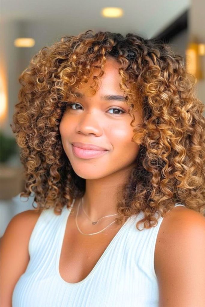 Voluminous afro with honey gold streaks