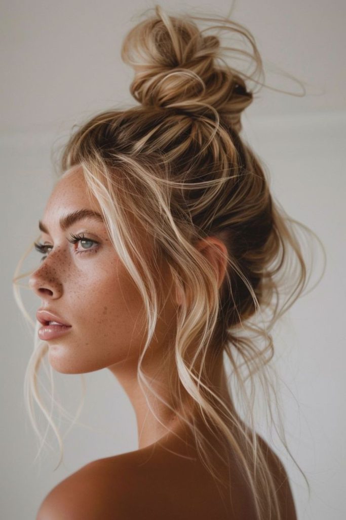 Messy bun with honey-tinted wisps glowing.