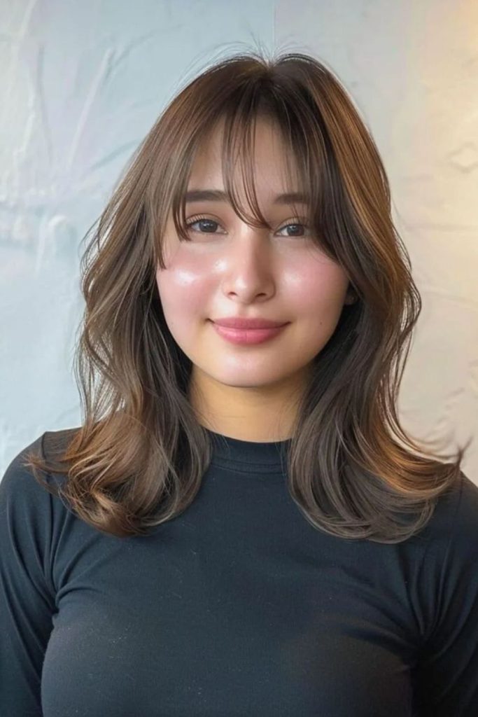 Asymmetric feathered fringe elongating face subtly