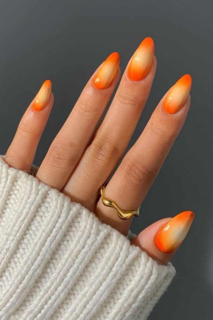 Tangerine nails with wedge-shaped accents.