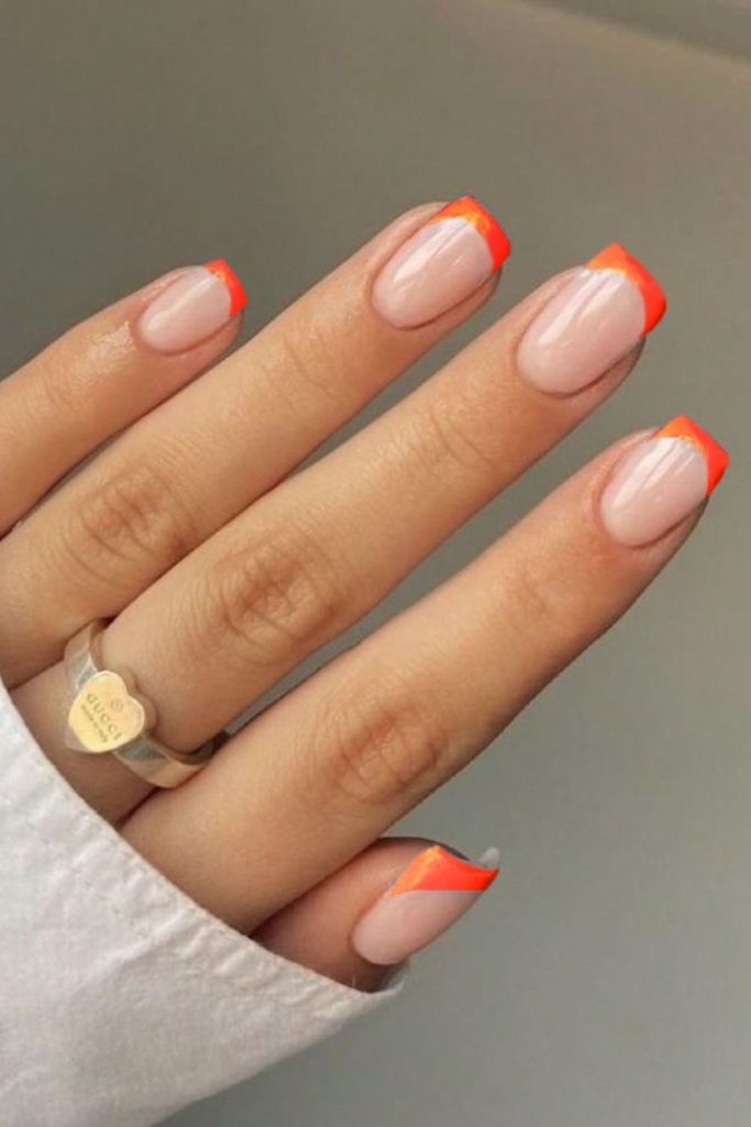 Coral arcs over soft nude nails.