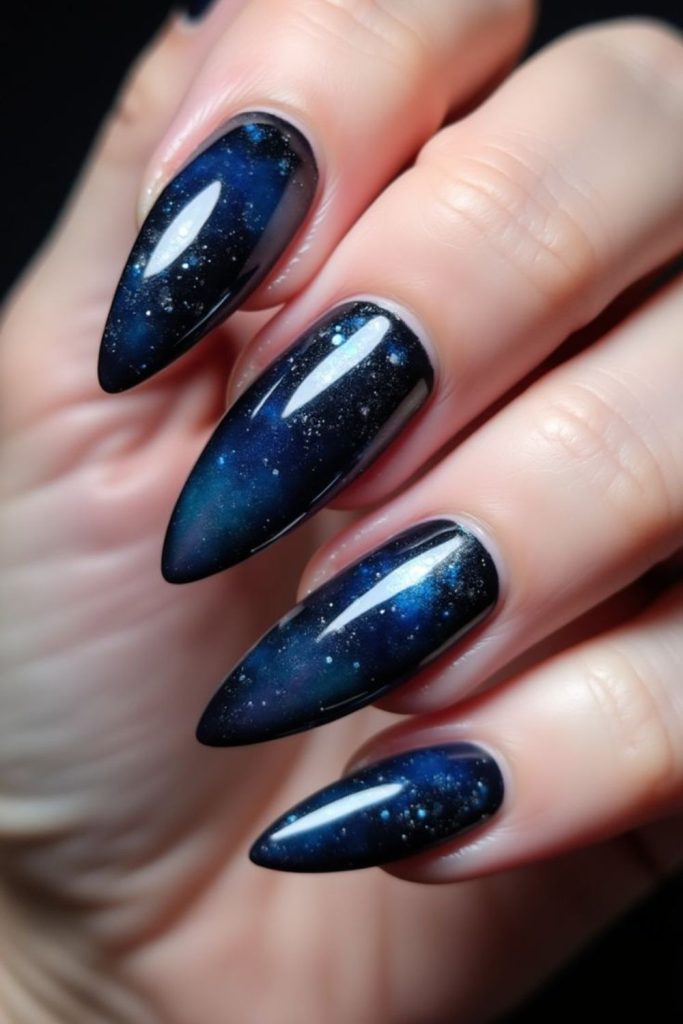 Dark blue nails with scattered holographic dust.