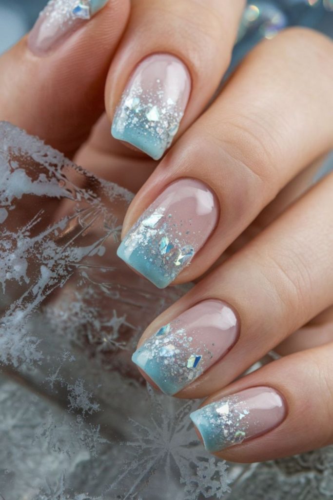 Translucent blue nails with silver shard glitter.