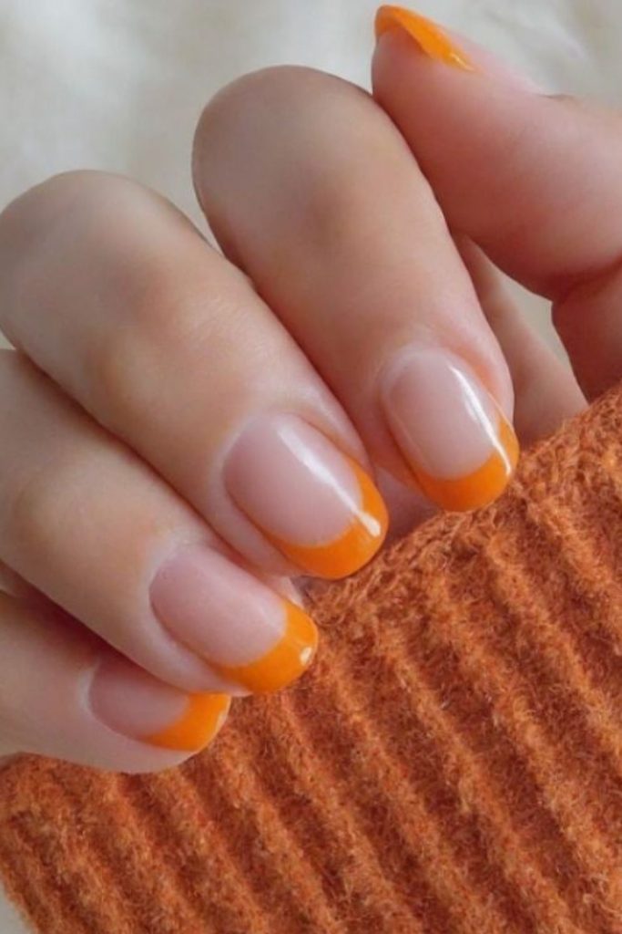 Fiery orange tips on caramel nails.