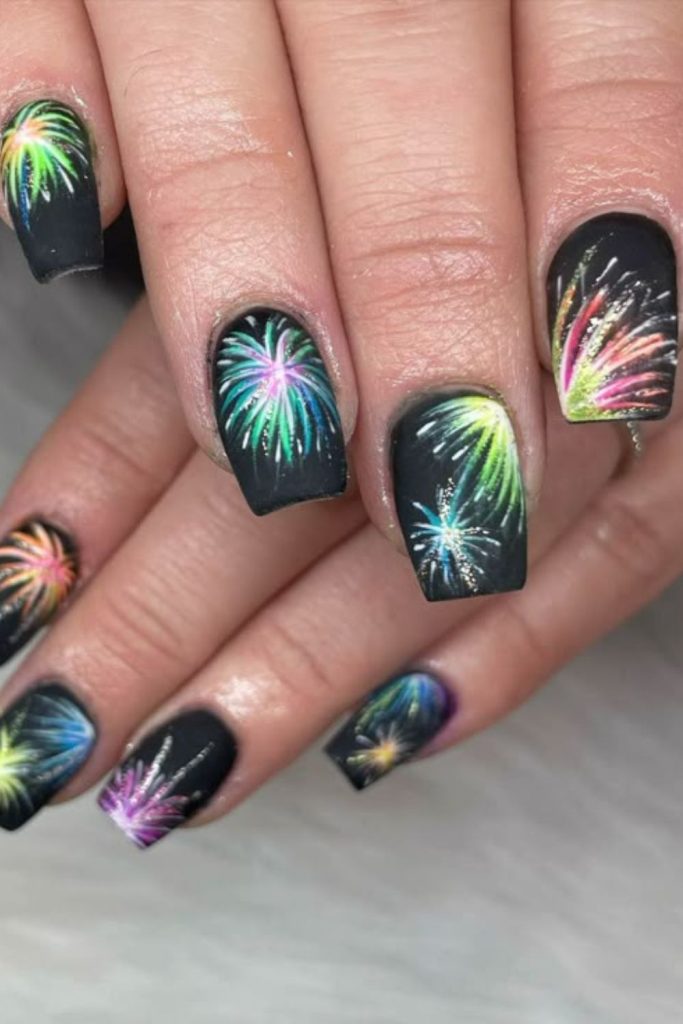 Black nails with colorful neon fireworks streaks.