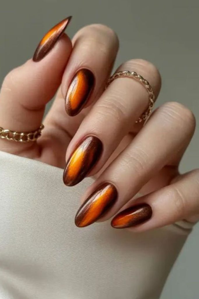 Amber nails with burnt orange streaks.