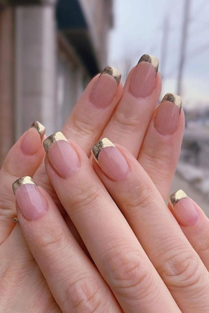 Gold square tips on beige nails.
