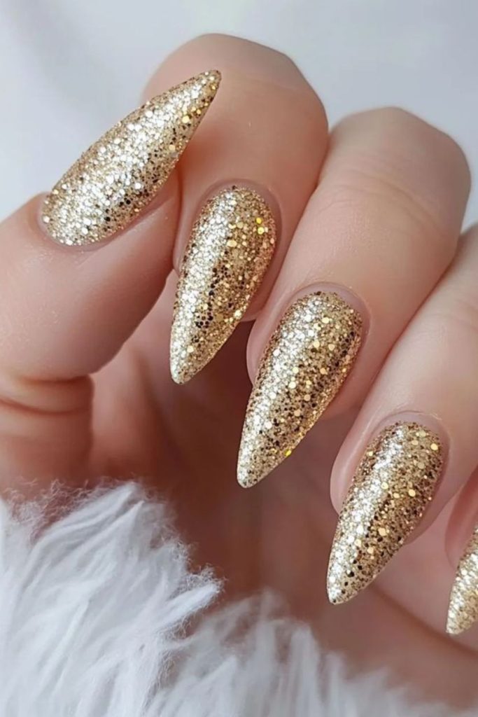 Taupe nails with golden spirals and flakes.