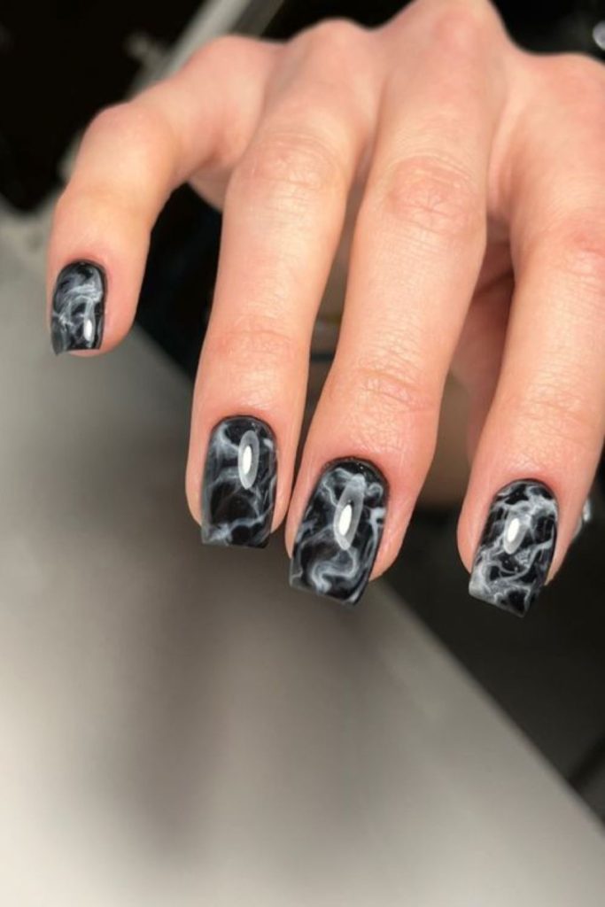 Jagged scratch marks on black nails