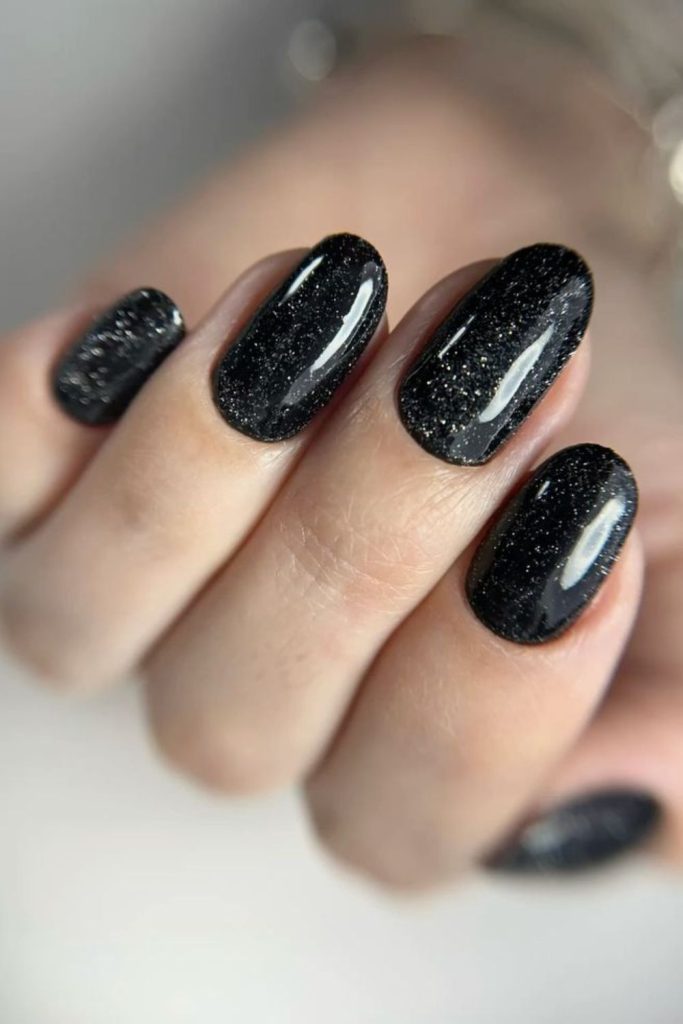 Velvety black nails with obsidian glitter highlights.