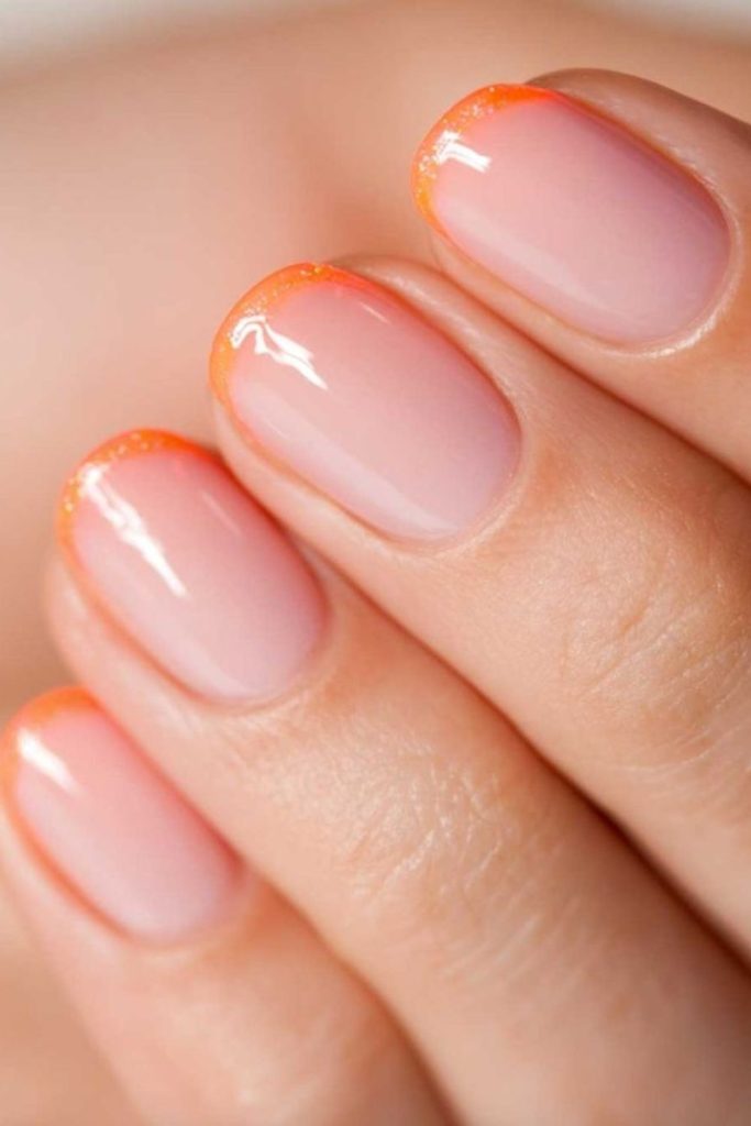 Soft peach arcs on translucent nails.